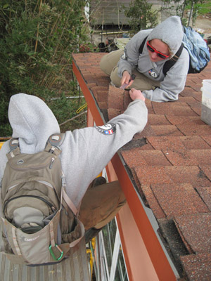 Michelle Warren and Kelly Hedgpeth tarring a roof